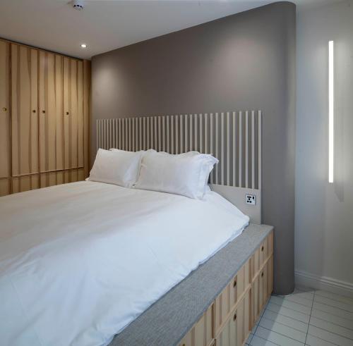 a large bed with white sheets and pillows on it at Trueman Court Luxury Serviced Apartments in Liverpool
