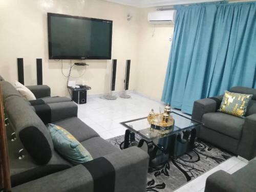 sala de estar con sofás y TV de pantalla plana. en Appartment in Keur Massar, en Keur Massar