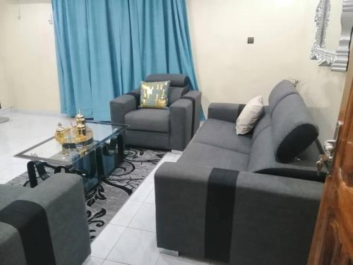 Sala de estar con 2 sofás y mesa de centro en Appartment in Keur Massar, en Keur Massar