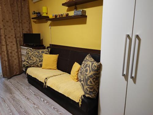 a black couch with yellow pillows in a room at Slnečné apartmány in Podhájska