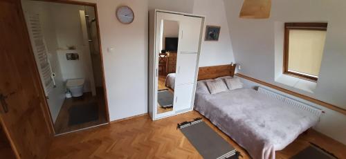 Habitación pequeña con cama y espejo. en Mazurska Rafa en Giżycko