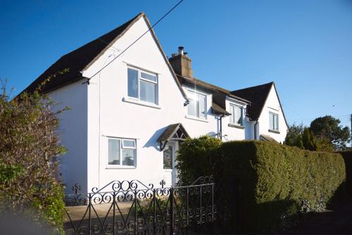 una casa blanca con una valla delante en Quiet Edwardian era House, Painswick, en Painswick