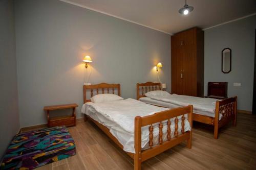 a bedroom with two beds and a rug at Amazing Magnolia in Batumi