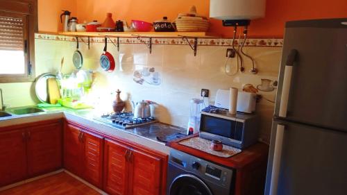 cocina con fogones horno superior junto a un microondas en The Guest House Bin Elouidane, en Bine el Ouidane