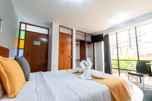 a bedroom with a large bed with a towel on it at KALUST HOTEL in Arequipa
