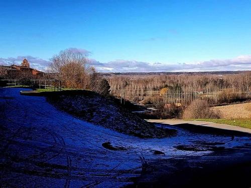 a river with snow on the side of it at Miradoralaribera Chalet rural in Alcoba de la Ribera