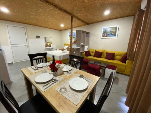 a dining room with a table and a yellow couch at Full Moon Apartments in Ksamil