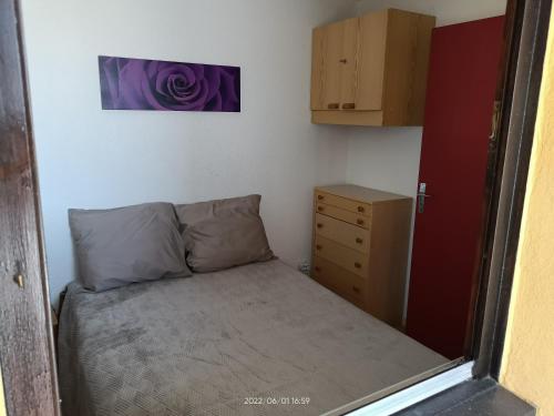 una piccola camera con letto e cassettiera di St Pierre La Mer,Appartement T2 en residence calme a Fleury