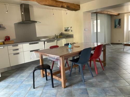 eine Küche mit einem Holztisch und Stühlen in der Unterkunft Maison indépendante, domaine VICHY LA TOUR in Abrest