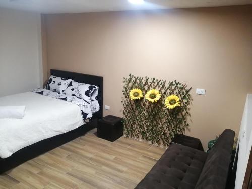 a bedroom with a bed and two sunflowers on the wall at FAKALI Homestay in Quito