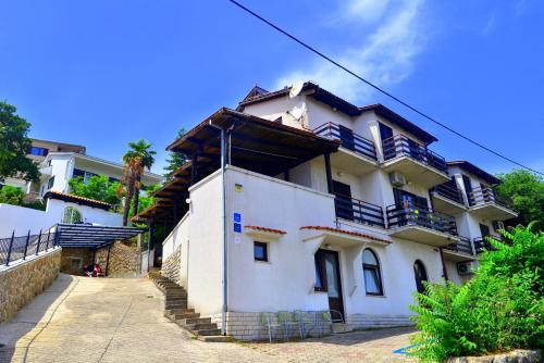 a large white building with stairs in front of it at Apartments Opatija Sea View in Opatija