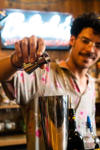 a man is pouring a drink into a glass at St Christopher's Inn Vienna in Vienna