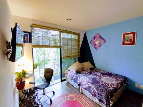 a bedroom with a bed and a desk and a window at Departamento COMPARTIDO en el Corazón de la Ciudad in Mexico City