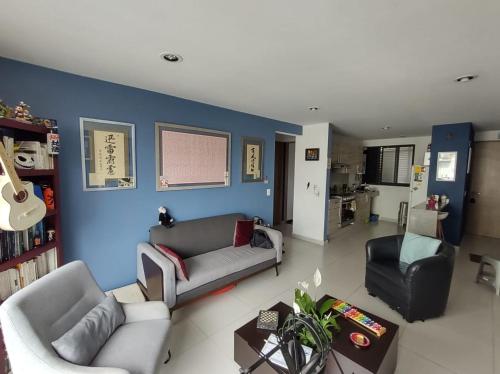 a living room with two couches and a blue wall at Departamento COMPARTIDO en el Corazón de la Ciudad in Mexico City