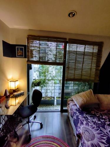 a bedroom with a desk and a bed and two windows at Departamento COMPARTIDO en el Corazón de la Ciudad in Mexico City