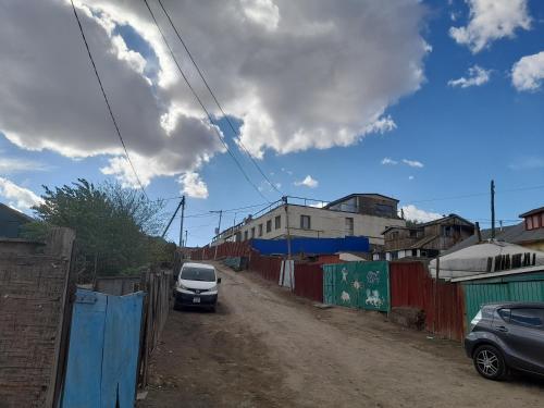 a car parked on a dirt road next to a fence at Gana's Guest House and Tours in Ulaanbaatar