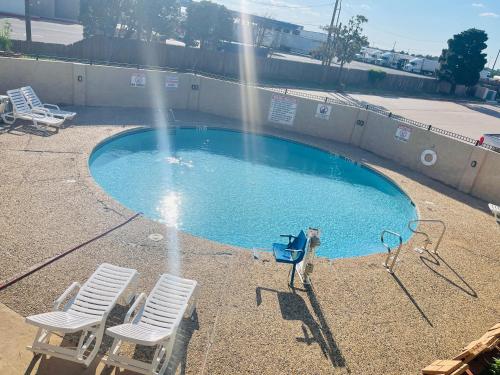 a pool with two chairs and a water fountain at Plaza Inn in Big Spring