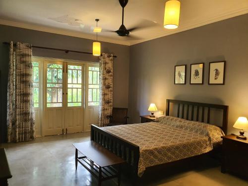 - une chambre avec un lit, deux tables et deux lampes dans l'établissement Lewella House Kandy, à Kandy