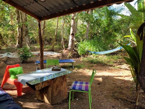 um grupo de cadeiras, uma mesa e uma rede de descanso em Jungle Tent 3x3, Latino Glamping & Tours, Paquera em Paquera