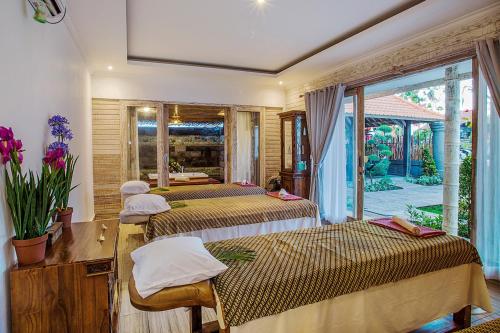 a bedroom with two beds and a window with a view at The Palm Grove Villas in Nusa Lembongan