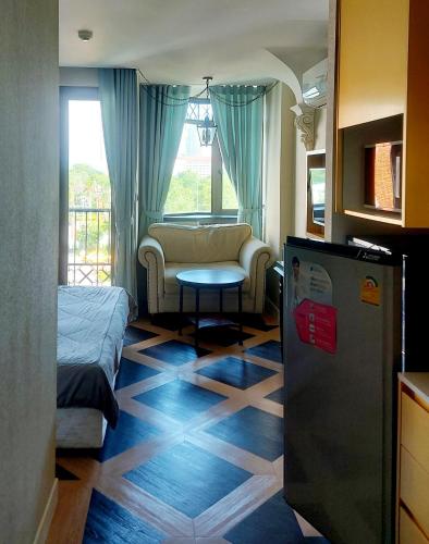 a room with a bed and a couch and a table at Espana Resort Pattaya Jomtien in Jomtien Beach