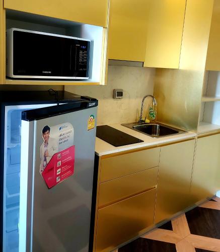 a kitchen with a refrigerator with a sign on it at Espana Resort Pattaya Jomtien in Jomtien Beach