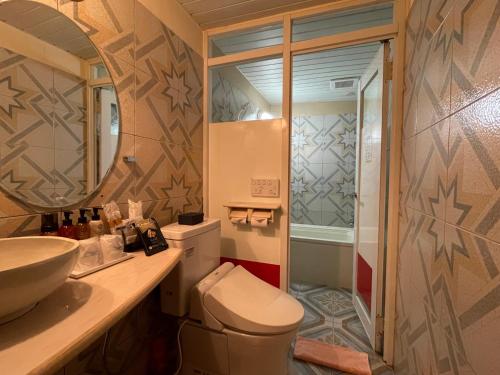 a bathroom with a toilet and a sink and a mirror at HOTEL マナティ in Akashi
