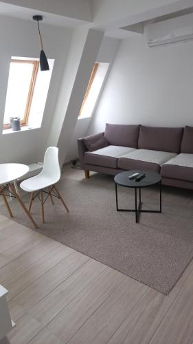 - un salon avec un canapé, une table et des chaises dans l'établissement Sunny apartment, à Skopje