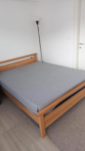 Una cama con marco de madera en una habitación. en Sunny apartment, en Skopje