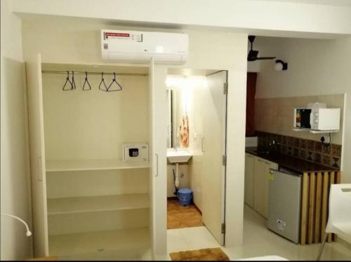 una cocina con fregadero y una puerta a una habitación en Cassiopeia Nest en Arambol