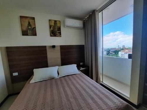 a bedroom with a bed with a large window at Lujoso Apartamento Nuevo, cerca de todo, moderno 100% amoblado con Netflix, Parqueo gratuito y WIFI. LUXURY in Santa Cruz de la Sierra