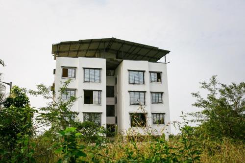 a white building with a dome on top of it at SPOT ON Pawan Villa in Gorhe