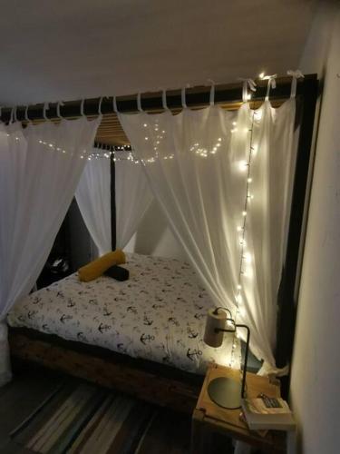 - une chambre avec un lit à baldaquin et des lumières dans l'établissement Appartement de 50m2 à 2 pas du port et plage!, à La Grande Motte