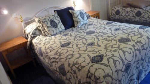 1 dormitorio con 1 cama con edredón azul y blanco en Kinneil Self Catering en Lamlash