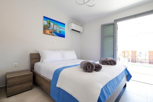 1 dormitorio con 2 camas y toallas. en AXS Top Floor Apartment en Aegina Town