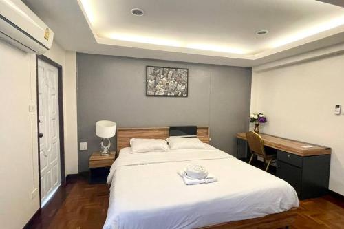 a bedroom with a large white bed and a desk at Cafe home in Chiang Mai