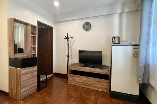 a living room with a refrigerator and a tv at Cafe home in Chiang Mai