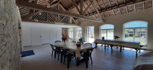 un grand salon avec une table et des chaises dans l'établissement 12 2et avec jardin 4-5per Les Gites Bigoudens 10 mn plages, à Plonéour-Lanvern