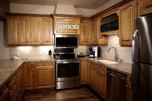 a kitchen with wooden cabinets and stainless steel appliances at Deer Valley Two Bedroom Loft Suite with Easy Access to all Park City has to Offer condo in Park City