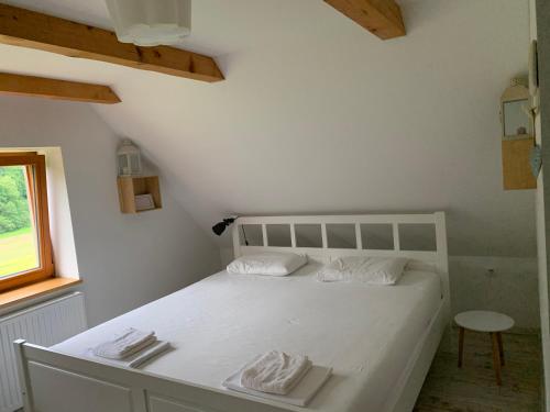 a white bed in a room with a window at Green place in Žetale