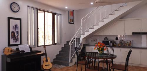 a living room with a staircase and a table with a guitar at Mountain Breath Retreat - Am Nui Tho in Yen Bai