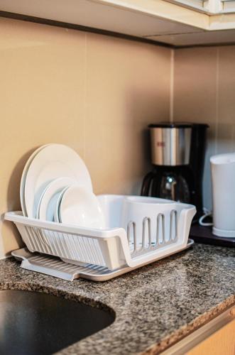 a white dish drying rack on a counter in a kitchen at Cozy and Classy Studio Across Airport Terminal 3 in Manila
