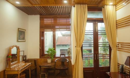 a room with a table and a large window at Phố Seoul Homestay And Spa in Hoi An