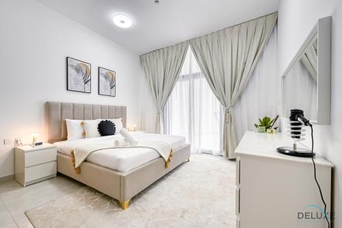 a white bedroom with a bed and a television at Urban 1BR at Binghatti Stars Dubai Silicon Oasis by Deluxe Holiday Homes in Dubai