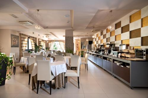 a restaurant with a table and chairs and a kitchen at Hotel La Cartiera in Vignola