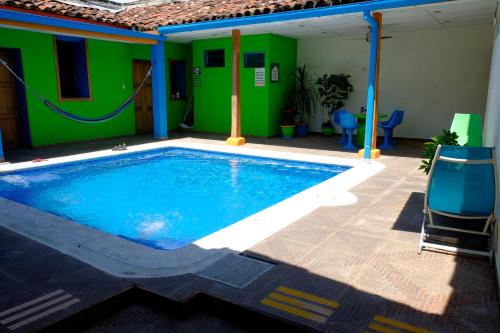 a swimming pool in a house with a green wall at Hostal Casa Verde in Santa Ana