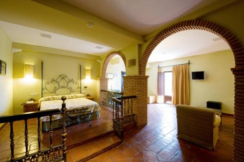 um quarto com uma cama e um arco num quarto em Balneario Cervantes em Santa Cruz de Mudela