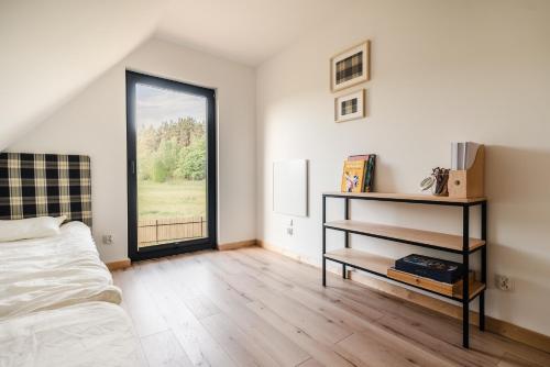 a bedroom with a bed and a large window at Na łące u pradziadka in Wiele