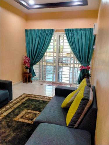 een woonkamer met een bank en een groot raam bij Rahman Homestay Pantai Johor - ISLAM SAHAJA in Alor Setar