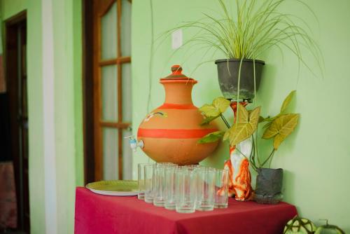 eine Vase auf einem Tisch mit Brille in der Unterkunft Green Garden Resort in Habarana
